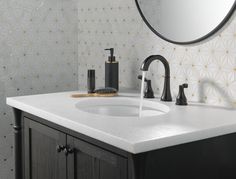 a bathroom sink with soap dispenser and black faucet