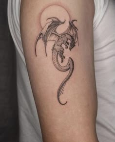 a woman's arm with a dragon tattoo on the left side of her body