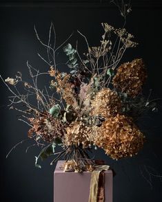 an arrangement of dried flowers in a vase