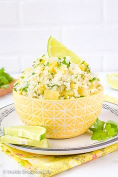 a yellow bowl filled with rice and garnished with cilantro on a plate