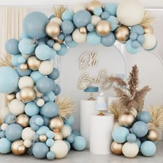 a blue, white and gold balloon arch for a baby shower