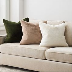 three pillows are sitting on the back of a couch