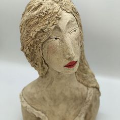 a ceramic sculpture of a woman's head with her eyes closed