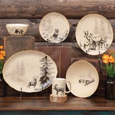 a table topped with plates and vases filled with flowers on top of a wooden shelf