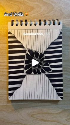 a spiral notebook with an image of a bow on the front and back cover that is black and white