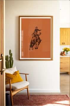 Framed orange poster of a cowboy riding bucking bronco hanging in a modern southwester home living room. Desert Casita, Bronc Rider, Montana House, Studio Vibes, Rodeo Poster, Eggshell Color