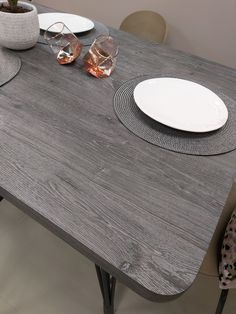 a wooden table with plates and glasses on it