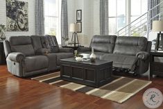 a living room with two recliners and a coffee table in front of the couch