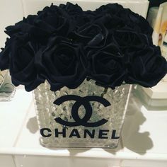 black roses in a chanel vase on a counter