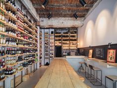 a long wooden table sitting in front of a wall filled with lots of wine bottles