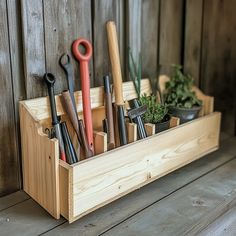 a wooden box filled with gardening tools on top of a table