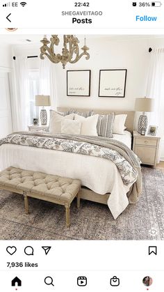 a bedroom with a bed, chandelier and two pictures hanging on the wall