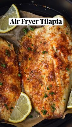 two pieces of chicken with lemons and parsley on top in a cast iron skillet