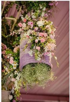 flowers hanging from the ceiling in front of a purple wall