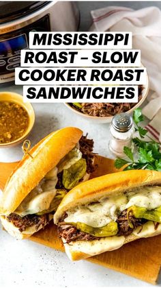 two sandwiches cut in half sitting on a cutting board next to an instant pot roaster