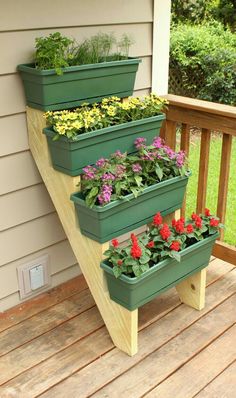 three planters on the side of a house with flowers in them