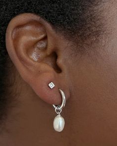 Classy and chic, we’re obsessed with the Willa ssilver Pearl Huggie Earrings in White Pearl—and you will be, too! A dainty cultured freshwater pearl dangles from a petite huggie for a lightweight style you’ll pair back with any stack. Metal Rhodium Over Brass Material White Pearl Closure Ear Post Size 1.8" Outside Diameter, 0.4"L X 0.3"W Charm Two Piercings Ear Aesthetic, Classy Silver Earrings, Everyday Hoop Earrings With Pearl Charm In Sterling Silver, Classic Silver Huggie Pearl Earrings, Minimalist Sterling Silver Huggie Earrings With Pearl Drop, Dainty Silver Single Pearl Earring, Dainty Silver Earrings With Pearl Charm, Sterling Silver Hoop Earrings With Pearl Drop For Everyday, Everyday Sterling Silver Hoop Earrings With Pearl Drop