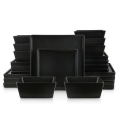 black dishes are stacked on top of each other in front of a white background,