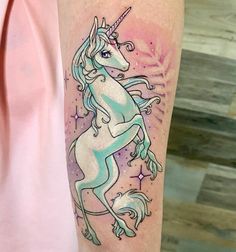 a woman's arm with a unicorn tattoo on it