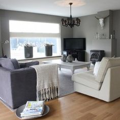 a living room filled with furniture and a flat screen tv on top of a wooden floor