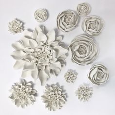 paper flowers are arranged on a white surface