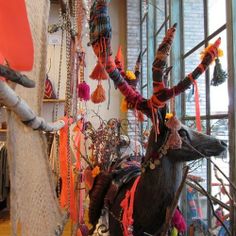 an animal statue is in the middle of a room with many items hanging from it's walls