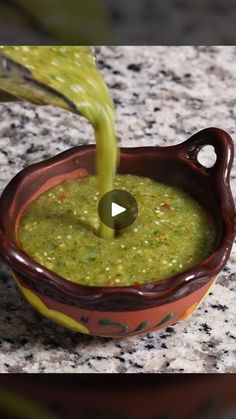 a green liquid being poured into a bowl