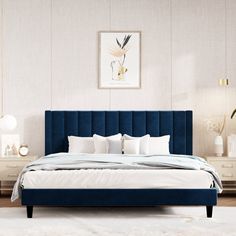 a bed with blue velvet headboard and white linens in a modern style bedroom