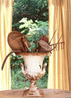 an old vase filled with utensils on top of a table