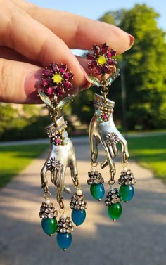 "Whimsical Silver Hands" Those One of a kind, unique design Statement Dangle Earrings, combine vintage charm with contemporary elegance. They are colorful assemblage piece of jewelry featuring silver-colored metal hands delicately embellished with tiny rhinestones that add a touch of sparkle and glamour.   From the tips of the graceful fingers, cascade of vintage rhinestones elegantly dangles, creating a mesmerizing play of light and color. At the end of the cascade are green/blue Jade Czech gla Luxury Handmade Retro Jewelry, Vintage Mexican Jewelry Novica, Cool Earrings Unique, Eclectic Earrings, Novica Jewelry, Unique Jewelry Vintage, Collage Jewelry, Assemblage Earrings, Funky Jewellery