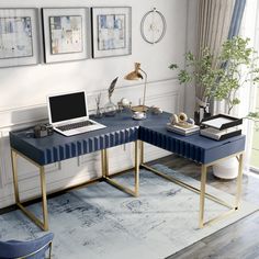 a laptop computer sitting on top of a blue desk next to a plant and chair