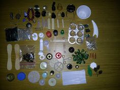 various items are laid out on a wooden table to be used as jewelry making supplies