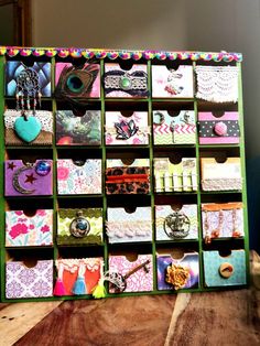 a wooden table topped with lots of drawers filled with different types of cards and magnets