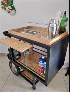 a bar cart with wine glasses and bottles on it