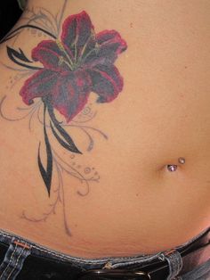 a woman's stomach with a flower tattoo on it