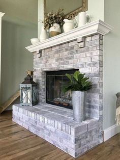 a living room with a brick fireplace and potted plants on top of the mantle