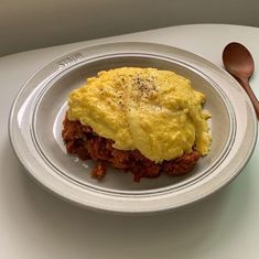 a white plate topped with an omelet on top of a table next to a fork