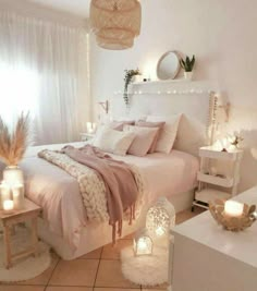 a bedroom with white walls and flooring has candles on the nightstands next to the bed