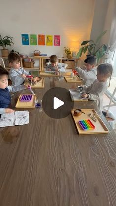 a group of children sitting around a wooden table