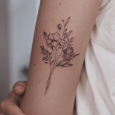 a woman's arm with a flower tattoo on the left side of her arm