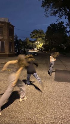 three young men are playing on the street at night