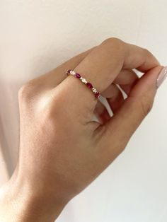 a woman's hand holding onto a white wall with a red and white ring on it