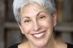 a woman with white hair smiling for the camera