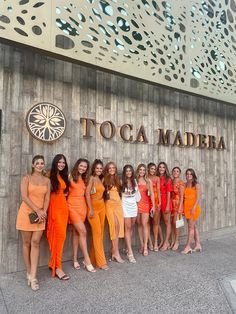 a group of women standing next to each other in front of a sign that says toca madera