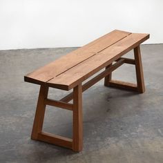 a wooden bench sitting on top of a cement floor