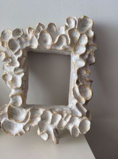 an ornate white frame is sitting on a table