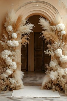 an archway decorated with flowers and feathers