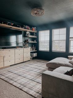 a living room filled with furniture and a flat screen tv mounted on the wall above it