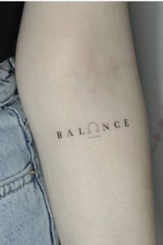 a woman's arm with the word balance tattooed on her left arm, in black ink