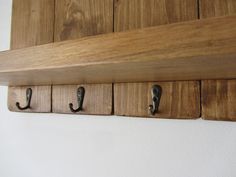 three hooks are attached to the wooden shelf